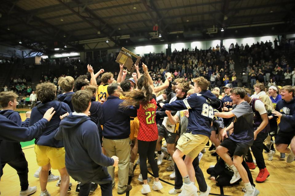 Delta boys basketball players and students celebrate winning the sectional championship game against New Castle at the New Castle Fieldhouse on Saturday, March 4, 2023.