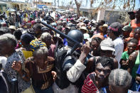 <p>Haitian policeman tries to keep order while Hurricane Matthew victims wait for the delivery of food from the UN’s World Food Programme in Roche-a-Bateaux, in Les Cayes, in the south west of Haiti, on October 12, 2016. (Hector Retamal/AFP/Getty Images)</p>