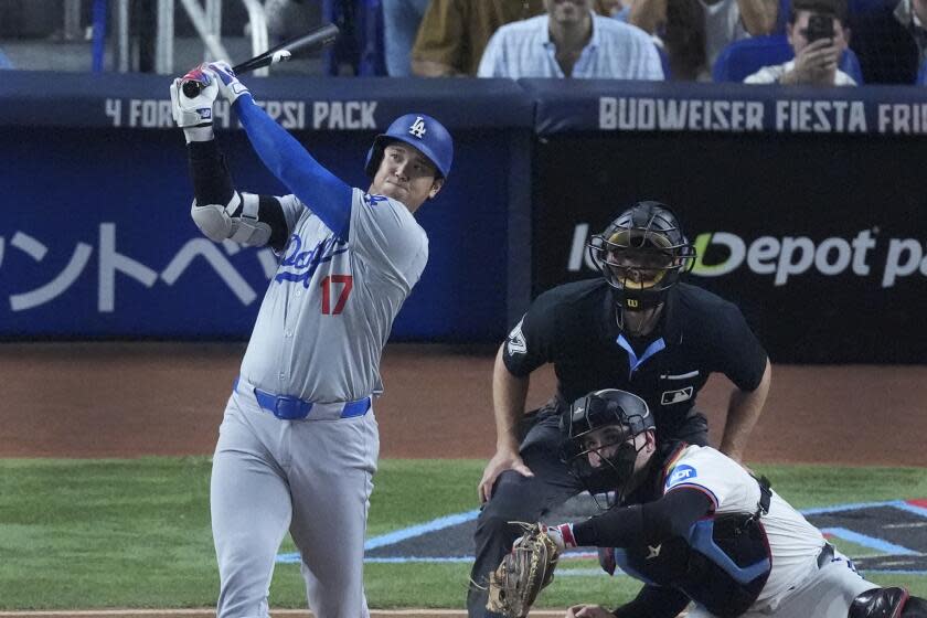 Los Angeles Dodgers' Shohei Ohtani, of Japan, watches the ball as he hits a home run scoring Hunter Feduccia during the third inning of a baseball game against the Miami Marlins, Tuesday, Sept. 17, 2024, in Miami. (AP Photo/Wilfredo Lee)