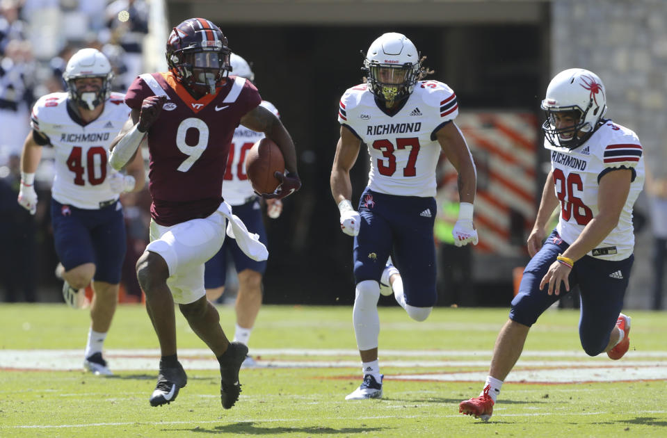 Virginia Tech wide receiver Tayvion Robinson (9) runs past Richmond punter Aaron Trusler (36) right, for a 60 yard kick return touchdown in the first half of the Richmond Virginia Tech NCAA college football game in Blacksburg, Va., Saturday, Sept. 25 2021. (Matt Gentry/The Roanoke Times via AP)