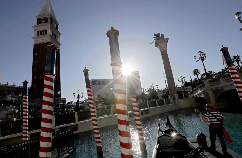 A musician plays guitar on a dock in a lagoon at the entrance to the Venetian Resort and Casino on the Las Vegas Strip.