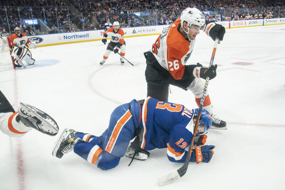 Philadelphia Flyers defenseman Sean Walker (26) vies for the puck against New York Islanders center Mathew Barzal (13) during the second period of an NHL hockey game Saturday, Nov. 25, 2023, in Elmont, N.Y. (AP Photo/Eduardo Munoz Alvarez)