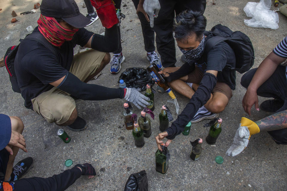 Protesters make Molotov cocktails during a rally against the military coup Saturday, March 27, 2021, in Yangon, Myanmar. The head of Myanmar’s junta on Saturday used the occasion of the country’s Armed Forces Day to try to justify the overthrow of the elected government of Aung San Suu Kyi, as protesters marked the holiday by calling for even bigger demonstrations. (AP Photo)