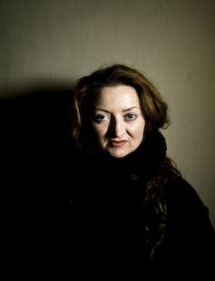 A young woman with large soulful eyes staring directly at the camera.