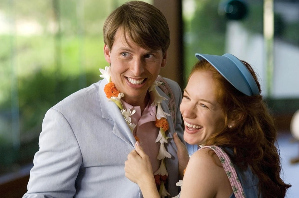 Jack McBrayer and Maria Thayer smiling, embracing, and wearing tropical leis