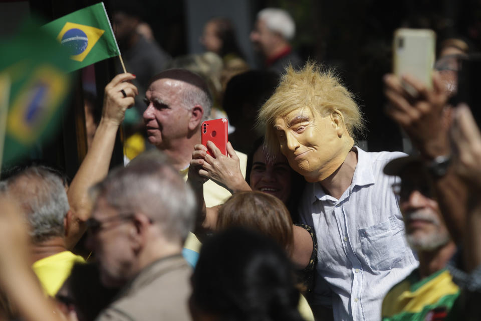 Un hombre con una máscara con la imagen del expresidente de Estados Unidos Donald Trump acude a un mitin del candidato a alcalde Alexandre Ramagem, en Río de Janeiro, el 18 de julio de 2024. (AP Foto/Bruna Prado)