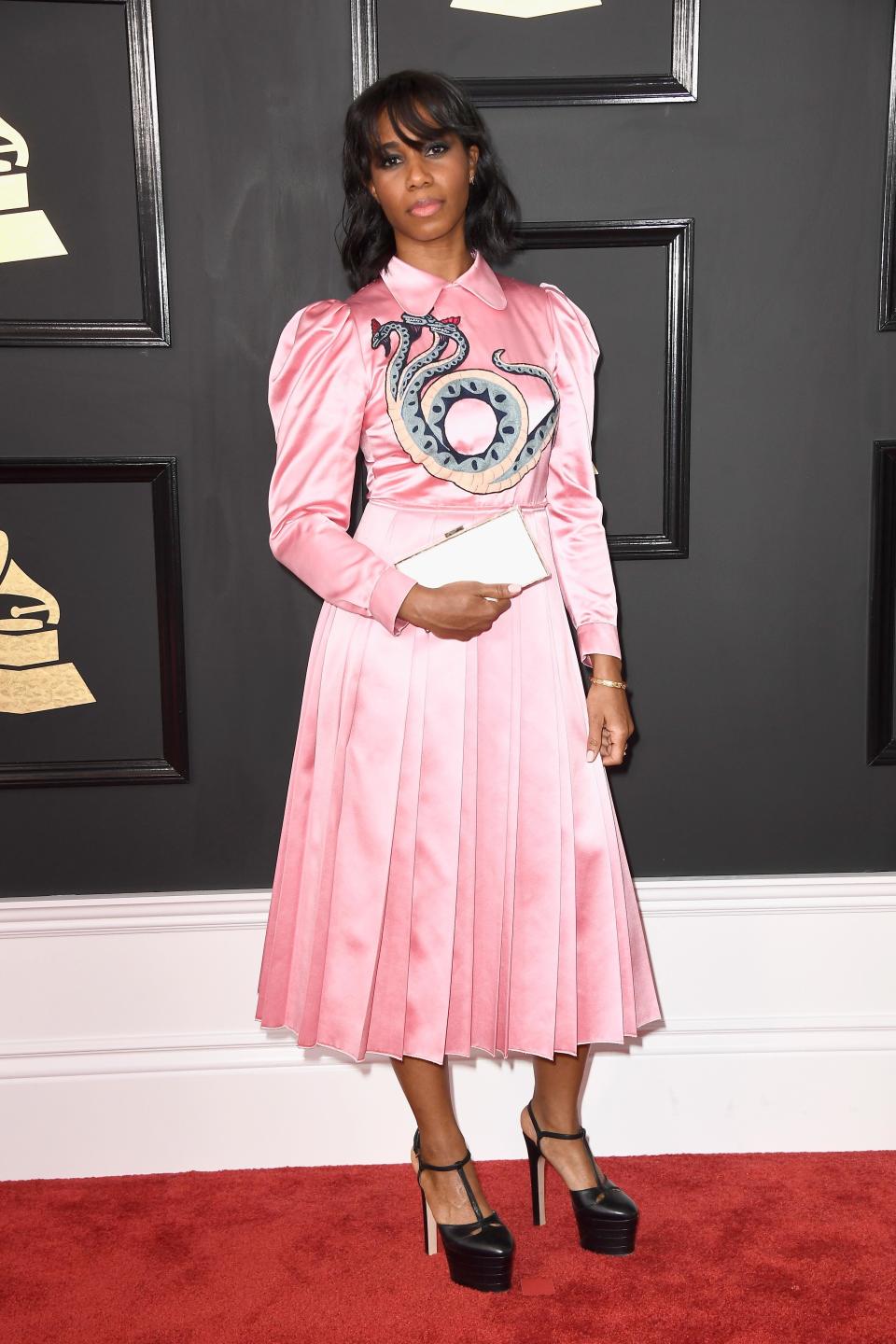 Santigold wearing the #RefreshTheTalk clutch, a high-tech accessory designed to raise awareness for social causes on the red carpet.