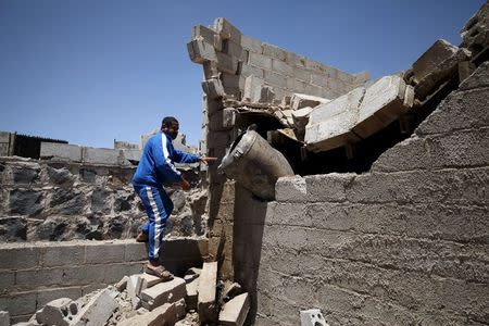 A man looks at shell which landed on his home from a nearby missile base after the base was struck by a Saudi-led coalition air strike, near Sanaa April 23, 2015. REUTERS/Mohamed al-Sayaghi
