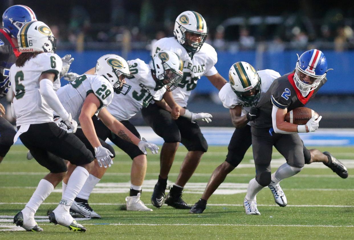 GlenOak's Avantae Burt (6), Ethan Lucas (29), Noah Williams (30) and Isaiah Shackleford (56) converge on Lake's Nate Baker last year.