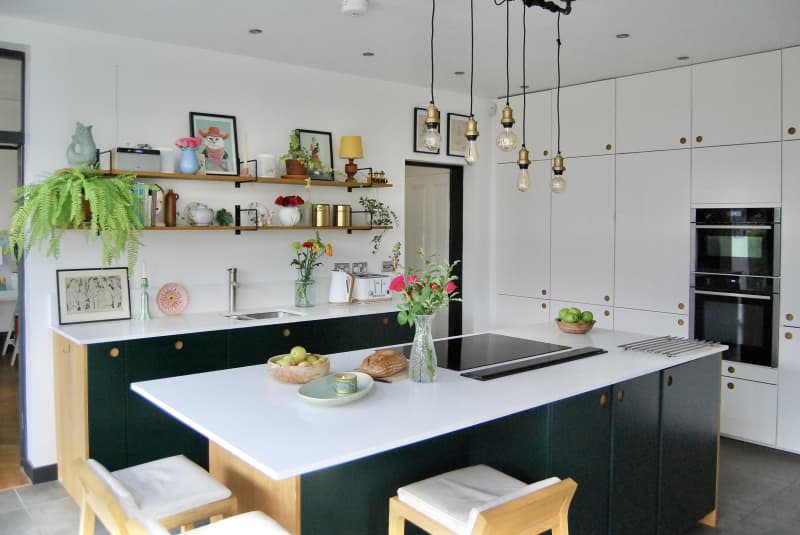 Kitchen with white counter tops black cabinets and wooden accents.