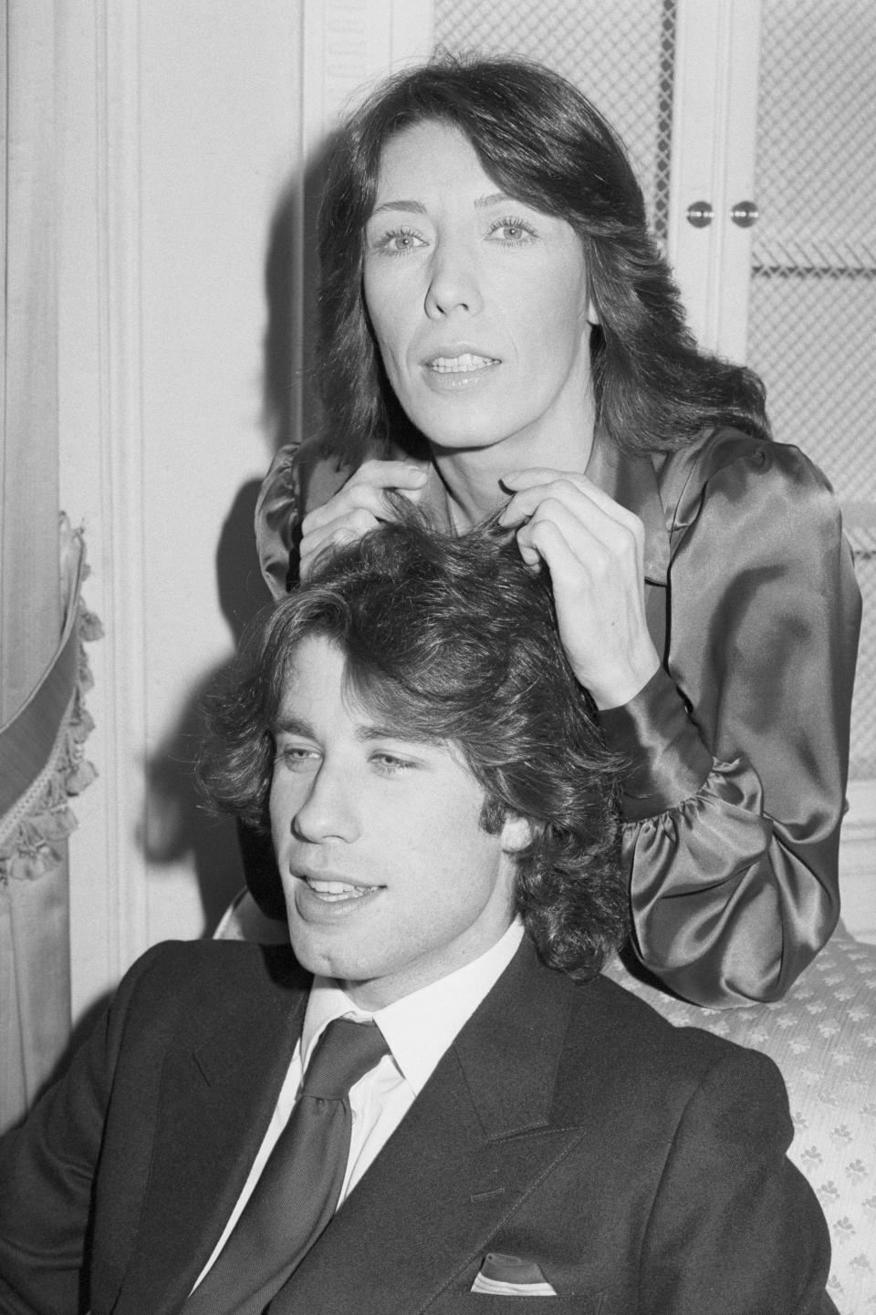 (Original Caption) New York: With Lily Tomlin tossing his curls, it's the good life for John Travolta, who is back in New York after he launched Saturday Night Fever for the opening of his third big film following Grease. Lily and John star in the film, Moment by Moment, which opens December 22. Here, they discuss their new film at the Waldorf Astoria Hotel.