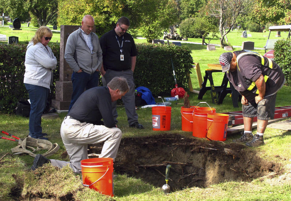 CORRECTS VICTIM'S NAME TO ROBIN PELKEY, INSTEAD OF HARRIET ROBIN PELKEY - FILE - In this Sept. 3, 2014, file photo, workers and medical examiner crew members exhume the body of Jane Doe #3 from a cemetery in Anchorage, Alaska. The remains of a woman known for 37 years only as Horseshoe Harriet, one of 17 victims of a notorious Alaska serial killer, have been identified through DNA profiling as Robin Pelkey, authorities said Friday, Oct. 22, 2021. (AP Photo/Rachel D'Oro, File)