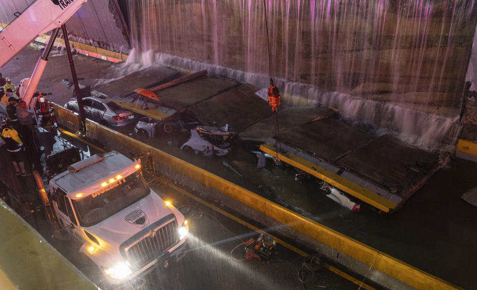 Rescue teams work at the place where a wall collapsed at the entrance of a tunnel in Santo Domingo, Dominican Republic, Saturday, Nov. 18, 2023. According to Civil Defense at least 9 people were killed when the wall fell down due to heavy rains. ( AP Photo/Eddy Vittini)