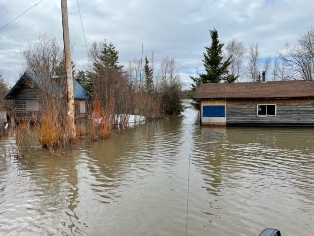 Homes in Little Buffalo River near Fort Resolution, N.W.T., seen on May 13, engulfed in water. (Tom Unka - image credit)