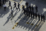 Security personnel march to duty outside the Evergrande headquarters in Shenzhen, China, Friday, Sept. 24, 2021. Things appeared quiet at the headquarters of the heavily indebted Chinese real estate developer Evergrande, one day after the day it had promised to pay interest due to bondholders in China. (AP Photo/Ng Han Guan)