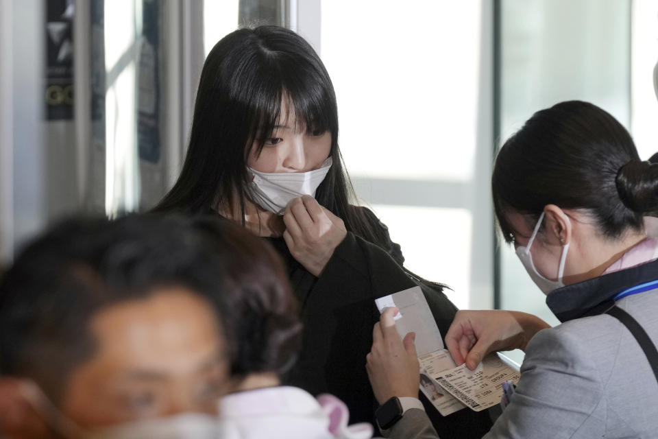 Japan's former Princess Mako, the elder daughter of Crown Prince Akishino, is checked at a boarding gate with and her husband Kei Komuro, not in picture, to board an airplane to New York Sunday, Nov. 14, 2021, at Tokyo International Airport in Tokyo. (AP Photo/Eugene Hoshiko)