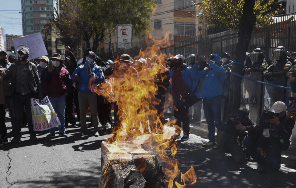 Maestros rurales queman un ataúd que representa al ministro boliviano de Educación mientras marchan contra la implementación del gobierno de clases virtuales en el país como medidas de precaución contra el nuevo coronavirus en La Paz, Bolivia, el miércoles 8 de julio de 2020. (AP Foto/Juan Karita)