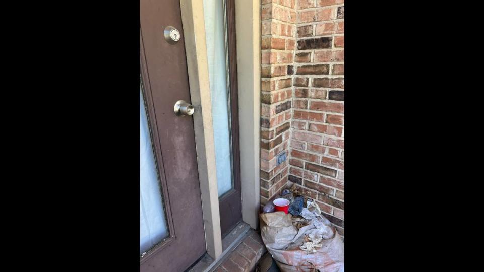 Trash is stacked next to the front door at 7312 Foley Drive in Belleville, where a squatter installed her own door knob and dead-bolt lock.