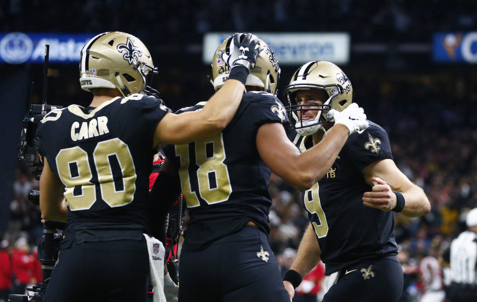 New Orleans Saints quarterback Drew Brees (9) and wide receiver Austin Carr (80) celebrate with wide receiver Keith Kirkwood (18) after Brees' touchdown pass to Kirkwood in the second half of an NFL football game against the Atlanta Falcons in New Orleans, Thursday, Nov. 22, 2018. (AP Photo/Butch Dill)