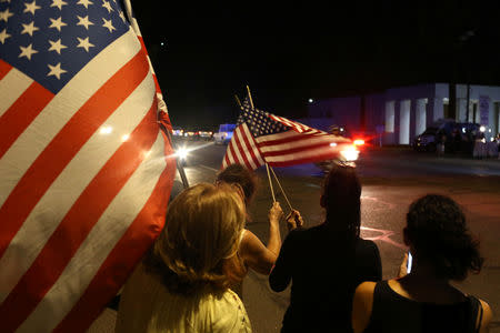 Mourners react as a hearse carrying the body of late U.S. Senator John McCain arrives in a procession in Phoenix, Arizona, U.S. August 25, 2018. REUTERS/Conor Ralph