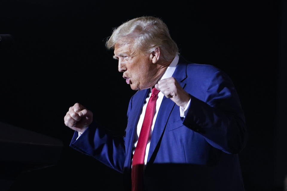 Former President Donald Trump greets the crowd with his fists in the air as he arrives at a campaign rally in Hialeah, Fla.,