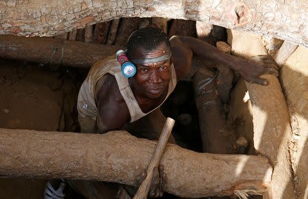 An artisanal gold miner emerges from a pit at an unlicensed mine near the city of Bouna, Ivory Coast, February 11, 2018. REUTERS/Luc Gnago/Files