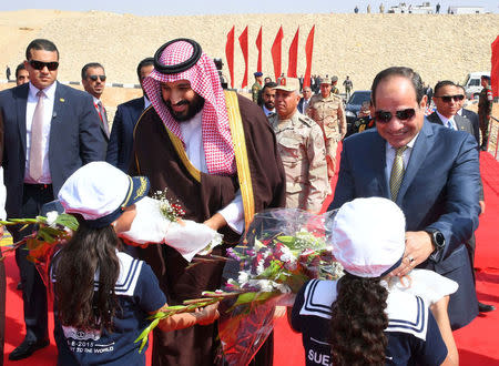 Saudi Crown Prince Mohammad Bin Salman (L) is welcomed with flowers during opening investment projects with Egyptian President Abdel Fattah al-Sisi in the Suez Canal at the city of Ismailia, Egypt, March 5, 2018, in this handout picture courtesy of the Egyptian Presidency. The Egyptian Presidency/Handout via REUTERS