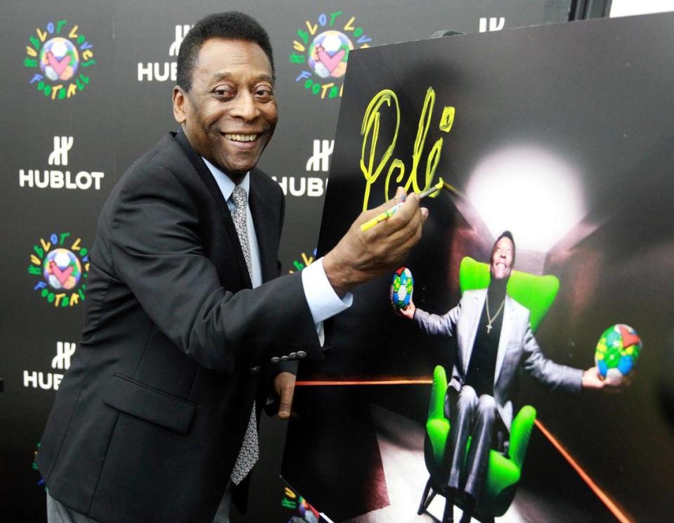 Foto de archivo. Pelé firma una foto suya para una publicidad relativa a la Copa Mundial de la FIFA Brasil 2014, en el estudio Wynwood de Romero Britto en Miami, el 28 de abril de 2014.