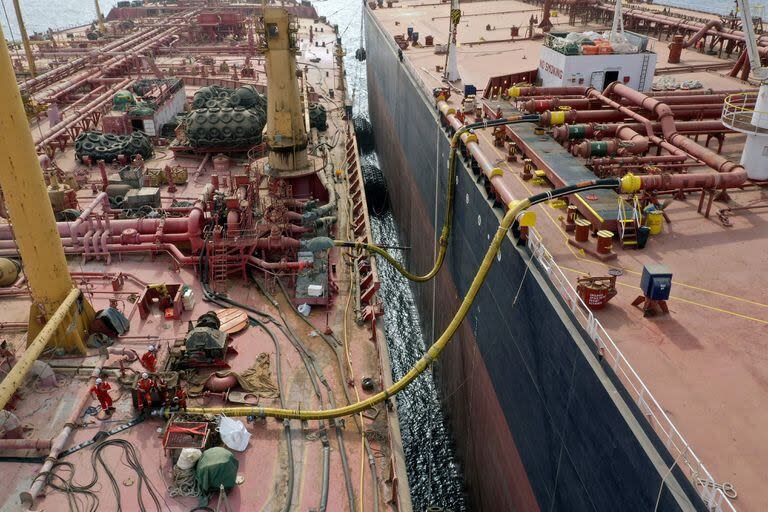 (FILES) Trabajadores se reúnen en la cubierta del petrolero FSO Safer (L) mientras se preparan para transferir petróleo al buque comprado por la ONU Nautica, en el Mar Rojo frente a la costa de la disputada provincia occidental de Hodeida en Yemen el 24 de julio de 2023
 (AFP)