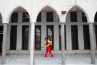 A volunteer sprays disinfectant in the Baitul Mukarram National Mosque before friday prayer amid concerns over the coronavirus disease (COVID-19) outbreak in Dhaka