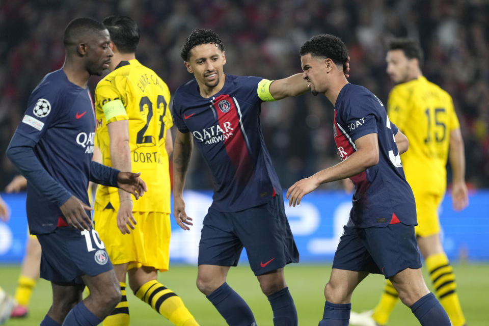 PSG's Marquinhos, centre, and PSG's Warren Zaire-Emery, right, react during the Champions League semifinal second leg soccer match between Paris Saint-Germain and Borussia Dortmund at the Parc des Princes stadium in Paris, France, Tuesday, May 7, 2024. (AP Photo/Lewis Joly)