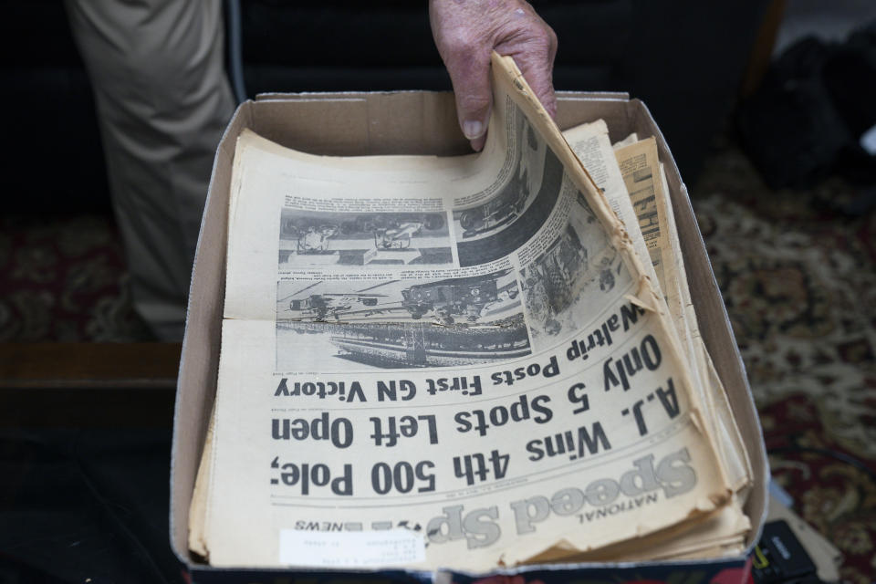 A.J. Foyt sifts through newspaper clippings inside his office, Wednesday, March 29, 2023, in Waller, Texas. Foyt drove during one of the deadliest eras in motorsports, and far too many of his racing contemporaries pulled off pit lane never to pull back in. (AP Photo/Godofredo A. Vásquez)