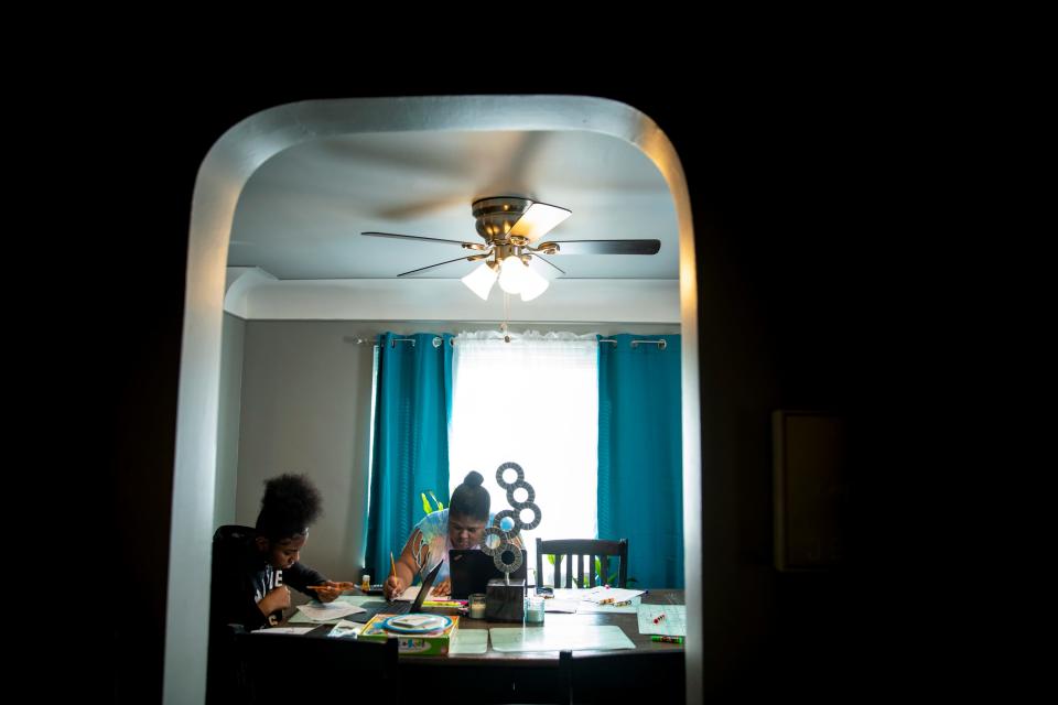 Sisters Destiny Taylor, 12, and Curiah Simpson, 18, work on their school work at the dining room table in their home in North College Hill on Thursday, April 2, 2020. Destiny is in the seventh grade at Mt. Healthy Jr. High School. Simpson is a senior at Diamond Oaks. 