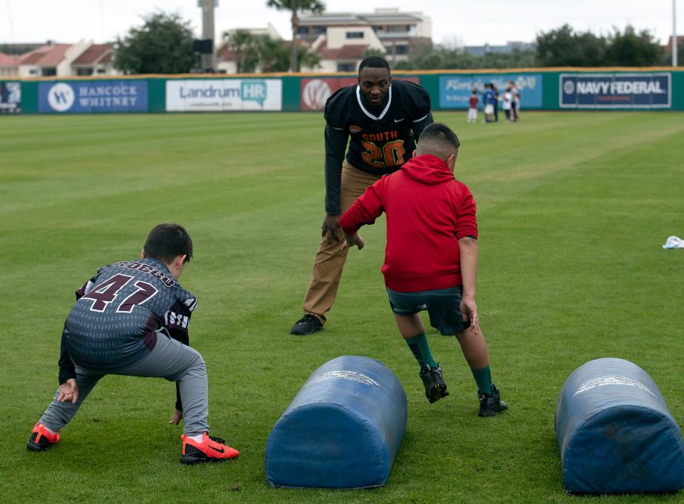 Davion Taylor of the University of Colorado puts a group of young athletes through their paces during a Senior Bowl Caravan stop in Pensacola on Friday, Jan. 24, 2020. 