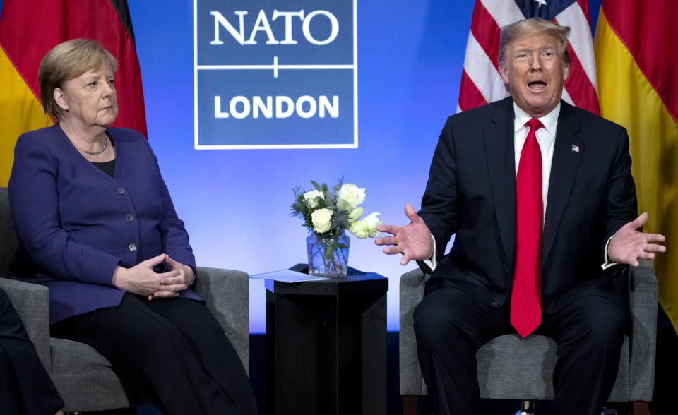 FILE - In this Wednesday, Dec. 4, 2019 file photo President Donald Trump meets with German Chancellor Angela Merkel during the NATO summit at The Grove in Watford, England. After more than a year of thinly veiled threats that the United States could start pulling troops out of Germany unless the country increases its defense spending to NATO standards, President Donald Trump appears to be going ahead with the hardball approach with a plan to reduce the American military presence in the country by more than 25 percent. (AP Photo/ Evan Vucci, file)
