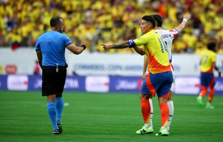 El colombiano #10 James Rodríguez y el paraguayo #08 Damián Bobadilla conversan con el árbitro argentino Darío Herrera durante el partido de fútbol del grupo D de la Copa América 2024 entre Colombia y Paraguay en el NRG Stadium de Houston, Texas, el 24 de junio de 2024 (Aric Becker)