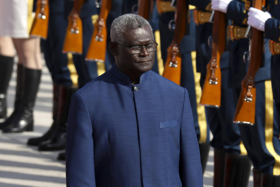 FILE - Solomon Islands Prime Minister Manasseh Sogavare reviews an honor guard during a welcome ceremony at the Great Hall of the People in Beijing, on Oct. 9, 2019. Solomon Islands Prime Minister Sogavare will visit China next week, highlighting the accelerating contest between Beijing and Washington for influence in the South Pacific. (AP Photo/Mark Schiefelbein, File)