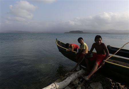 Guna children fish sitting on a canoe at Puerto Escoses in the Caledonia island in the region of Guna Yala April 4, 2014. REUTERS/ Carlos Jasso