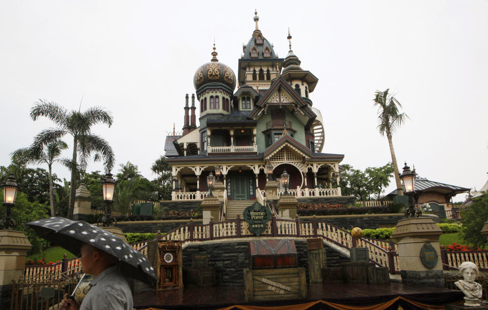 FILE - In this Thursday, May 16, 2013 file photo, a man walks past the Mystic Manor one day before the official opening for the public of the new attraction Mystic Point at the Hong Kong Disneyland. Hong Kong Disneyland is adding an Iron Man-themed area in the hopes that the Marvel superhero's success at the Chinese box office will help draw more visitors to the underachieving resort. The park said Tuesday, Oct. 8 that the Iron Man Experience is planned to open by late 2016. (AP Photo/Kin Cheung, File)