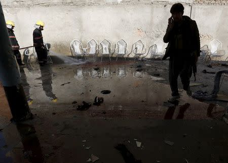 Firefighters spray water to clean the site of a suicide attack in Jalalabad, Afghanistan January 17, 2016. REUTERS/ Parwiz