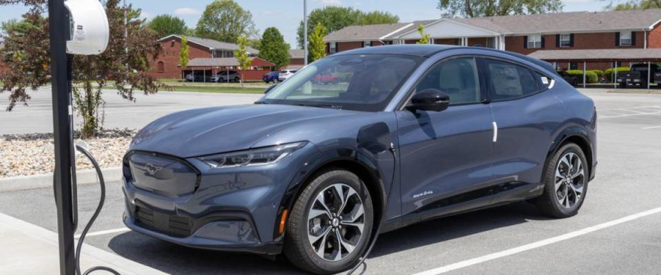 Ford Mustang Mach-E SUV display at a charging station.