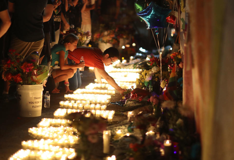 People visit&nbsp;a makeshift&nbsp;memorial outside Pulse on June 12, 2017, one year after a gunman killed 49 people there. Since the shooting, members of the LGBTQ community have rallied behind the fight to end gun violence. (Photo: Joe Raedle / Getty Images)