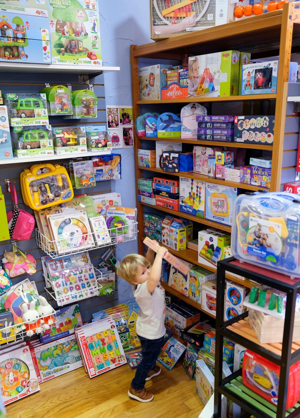 Becks, 4, grabs a game from the shelf at the Learning Tree Toys, Books & Games, 7638 N Western Ave, during Small Business Saturday, November 27, 2021.