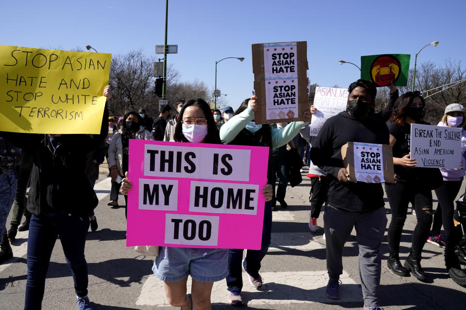 FILE - This March 20, 2021, file photo shows people holding signs as they march during a rally to support Stop Asian Hate at the Logan Square Monument in Chicago. A national coalition of civil rights groups will release on Wednesday, July 28, 2021, a comprehensive, state-by-state review of hate crime laws in the United States. Members of the coalition say the report sets the stage for bolstering the efficacy of current law and addresses racial disparities in how the laws are enforced. (AP Photo/Nam Y. Huh, File)