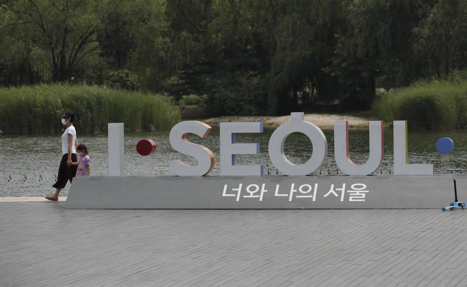 Visitors wearing face masks to prevent the spread of the new coronavirus walk at a park in Seoul, South Korea, Saturday, June 20, 2020. (AP Photo/Lee Jin-man)