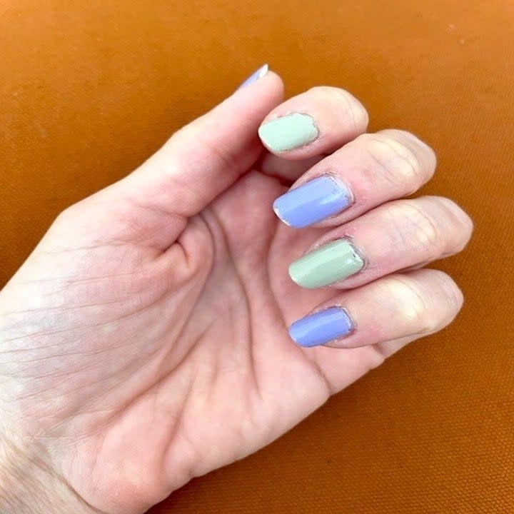 open hand with grey and purple polish