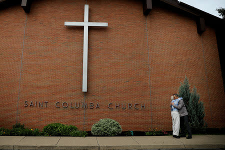 Members of the Saint Columbia Church embrace each other after Sunday Mass in Bloomsburg, Pennsylvania, U.S., August 19, 2018. REUTERS/Carlos Barria