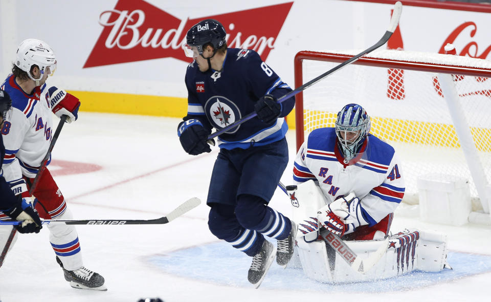 Winnipeg Jets' Saku Maenalanen (8) jumps out of the way as New York Rangers goaltender Jaroslav Halak (41) makes a save on a shot from the point during the second period of an NHL hockey game Friday, Oct. 14, 2022, in Winnipeg, Manitoba. (John Woods/The Canadian Press via AP)