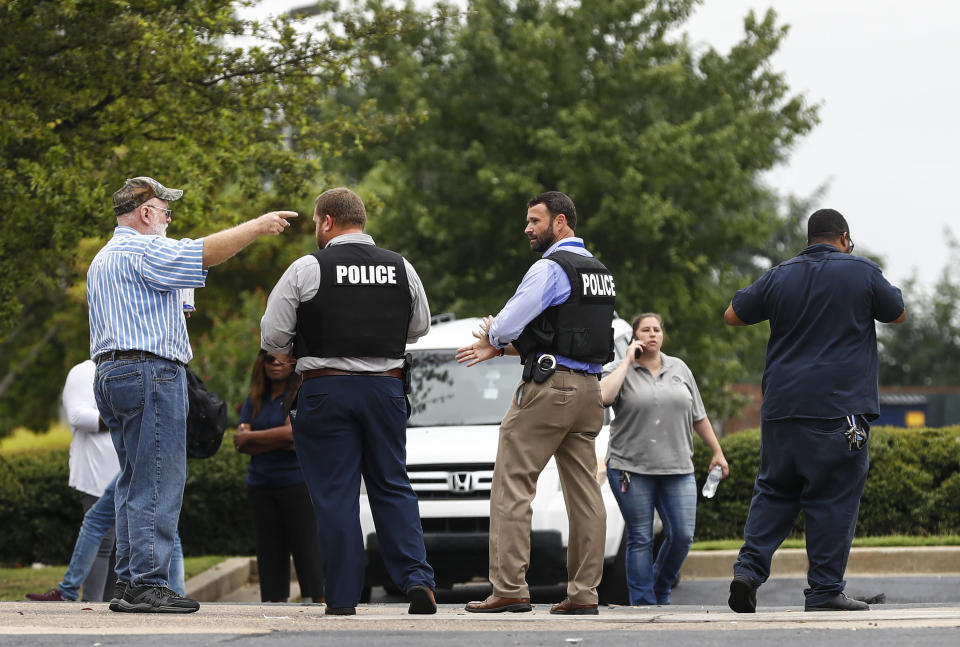 Law officials talk with Walmart employees and family members at a nearby parking lot following a shooting at the store, Tuesday, July 30, 2019, in Southaven, Miss. A gunman fatally shot two people and wounded a police officer before he was shot and arrested Tuesday at the Walmart in northern Mississippi, authorities said. (Mark Weber/Daily Memphian via AP)