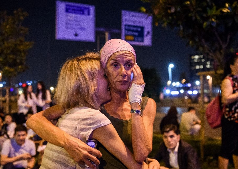 Passengers embrace outside Istanbul's international airport after triple suicide bombings. Photo: AP